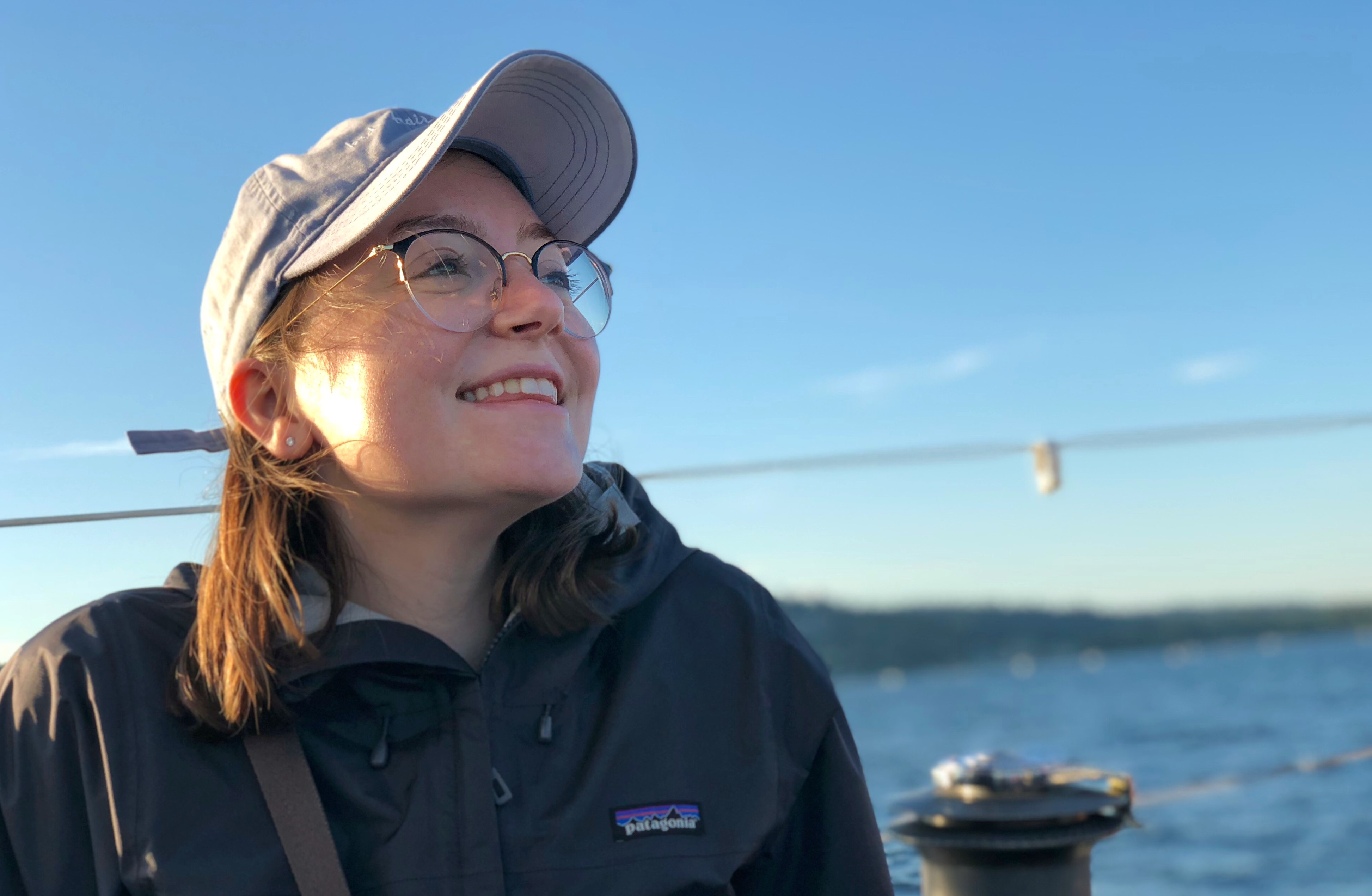 Jaylin Herskovitz on a sailboat on a lake. She is looking to the right and smiling.